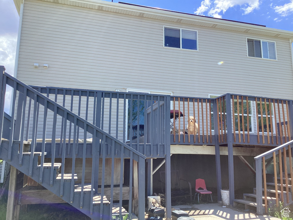 Back of property with stairs and a wooden deck