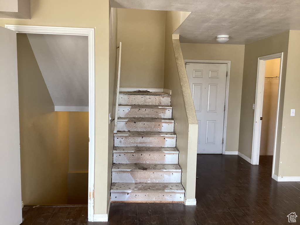 Stairs featuring wood finished floors and baseboards