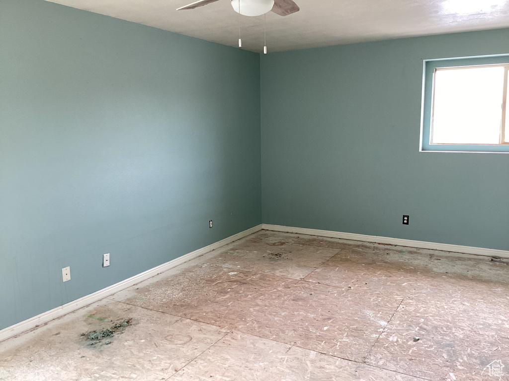 Spare room with baseboards and a ceiling fan