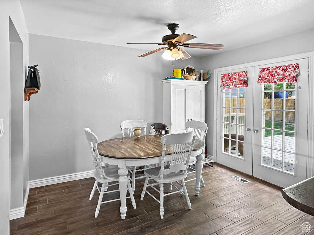 Dining room with wood finished floors, a ceiling fan, french doors, and baseboards