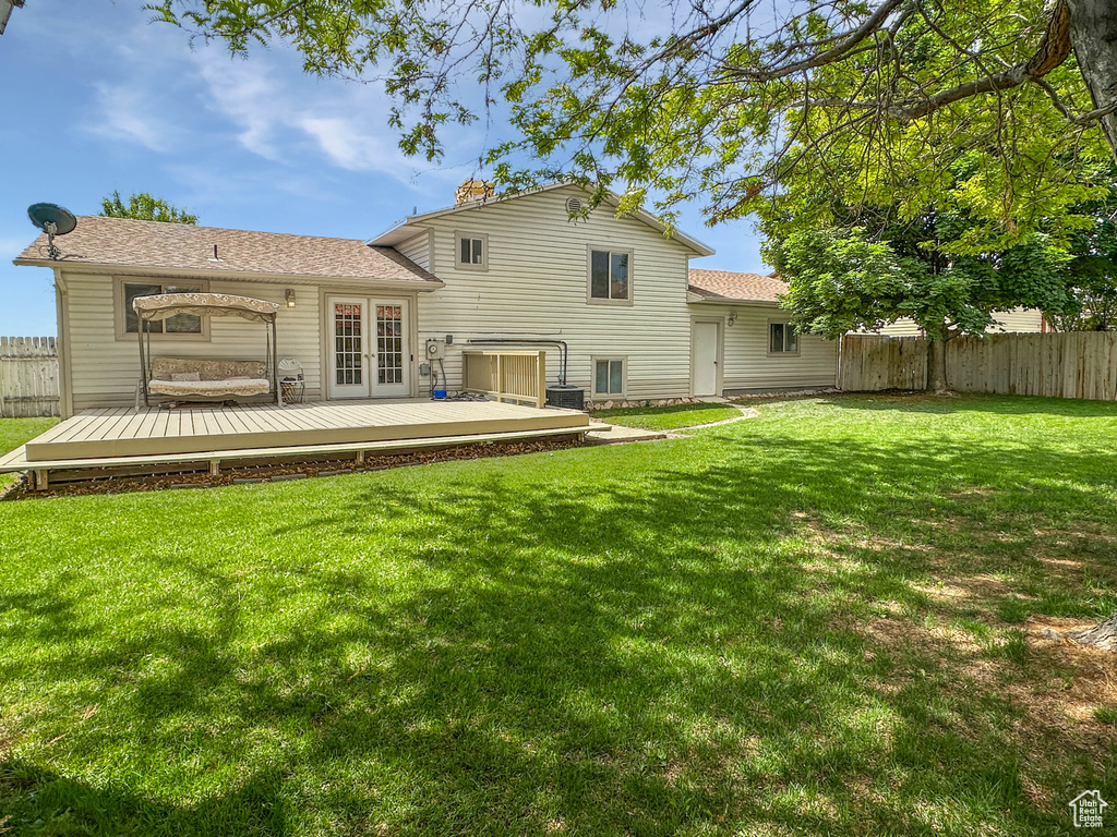 Back of house with a wooden deck and french doors