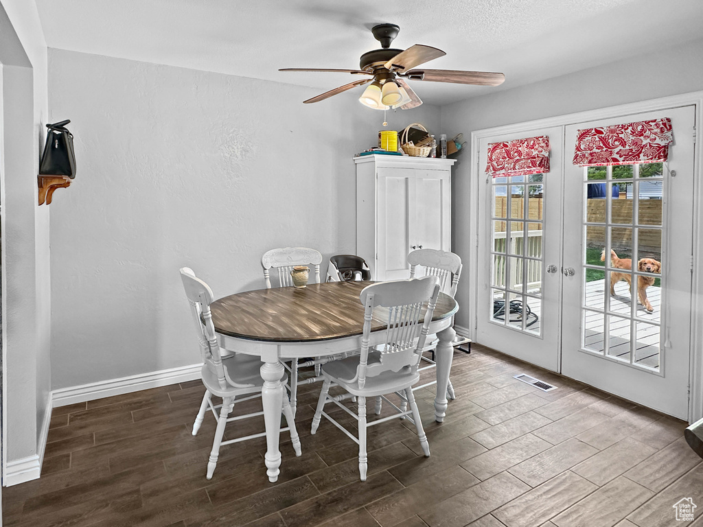 Dining space with wood finish floors, french doors, ceiling fan, and baseboards