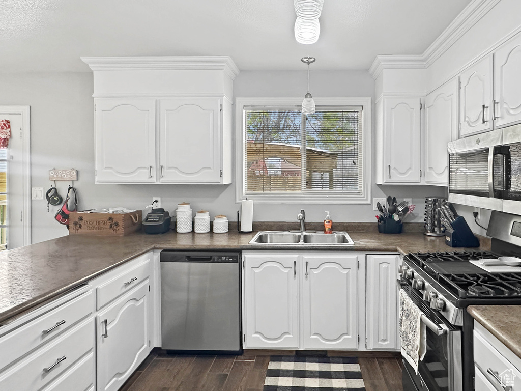 Kitchen featuring stainless steel appliances, white cabinetry, and a sink