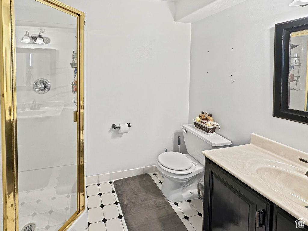 Full bathroom with vanity, a shower stall, and toilet