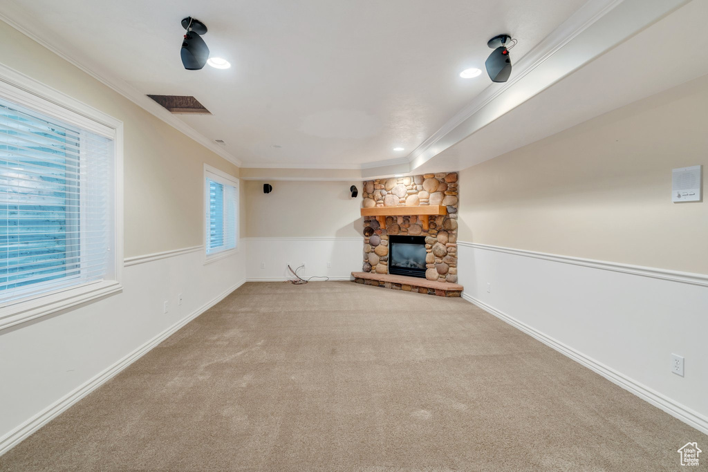 Unfurnished living room featuring crown molding, a fireplace, carpet floors, and recessed lighting