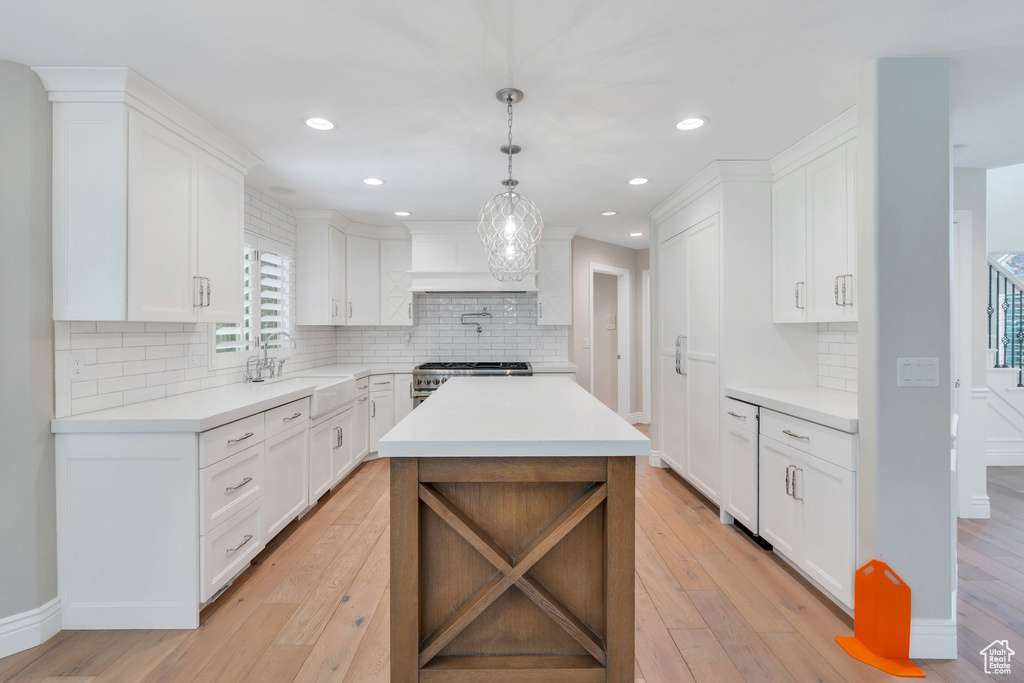 Kitchen featuring a sink, light countertops, light wood-style floors, and recessed lighting