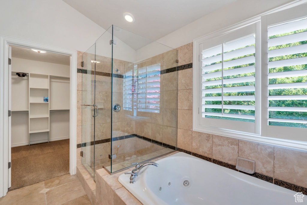 Full bathroom with a shower stall, a tub with jets, a spacious closet, and tile patterned floors