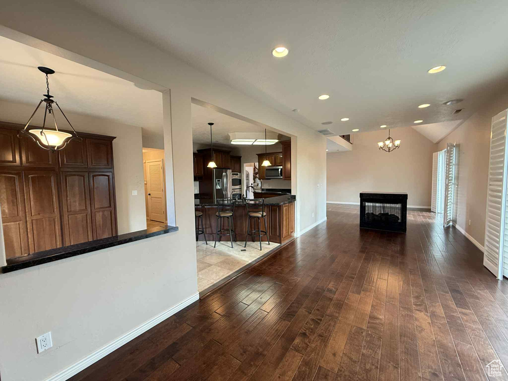 Living area featuring hardwood / wood-style flooring, baseboards, recessed lighting, a chandelier, and a multi sided fireplace