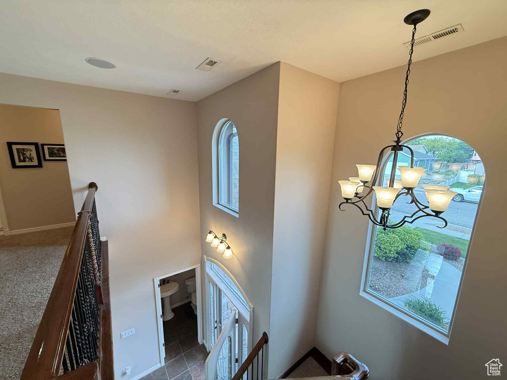 Stairs with a chandelier and baseboards
