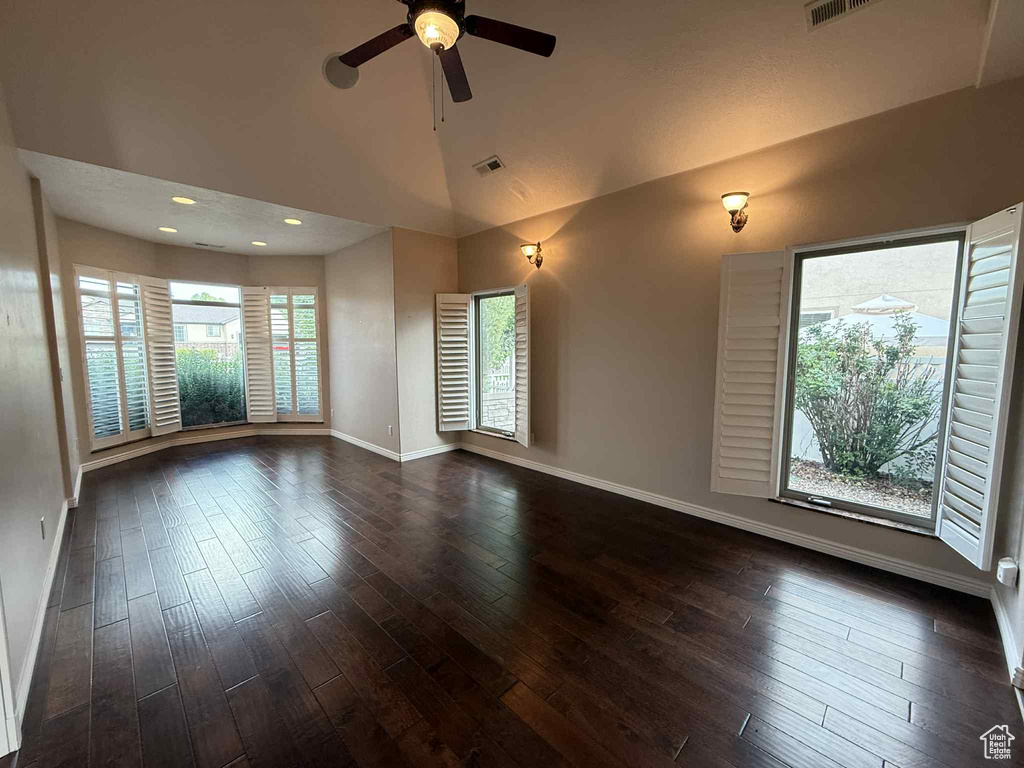 Empty room featuring baseboards, dark wood-style floors, ceiling fan, recessed lighting, and high vaulted ceiling