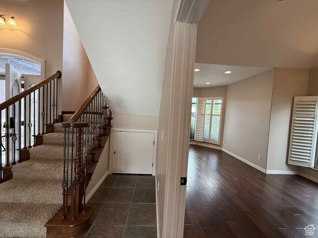 Staircase featuring baseboards, wood finished floors, and recessed lighting