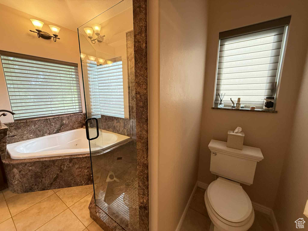 Bathroom featuring a garden tub, tile patterned floors, toilet, and an enclosed shower