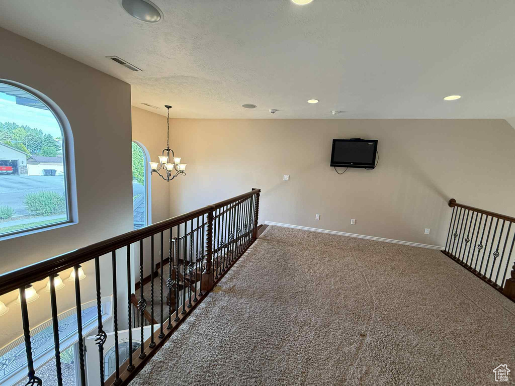 Corridor featuring a chandelier, carpet flooring, baseboards, recessed lighting, and an upstairs landing