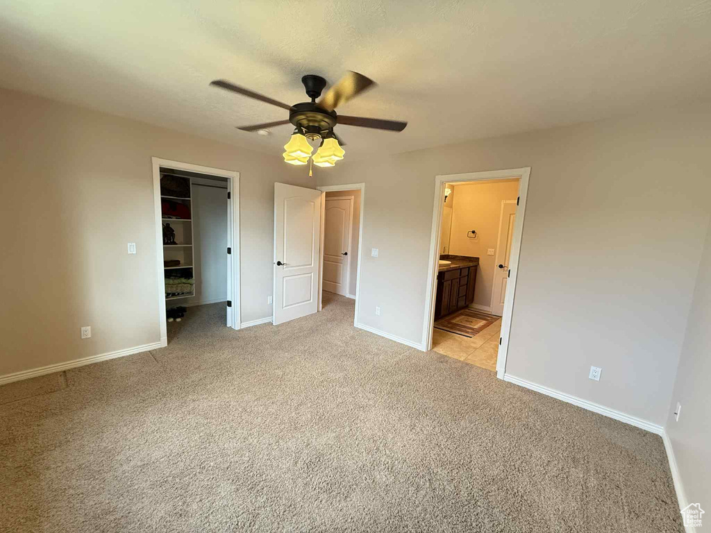 Unfurnished bedroom featuring light colored carpet, baseboards, and a spacious closet