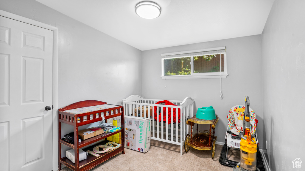 Bedroom featuring a crib and carpet