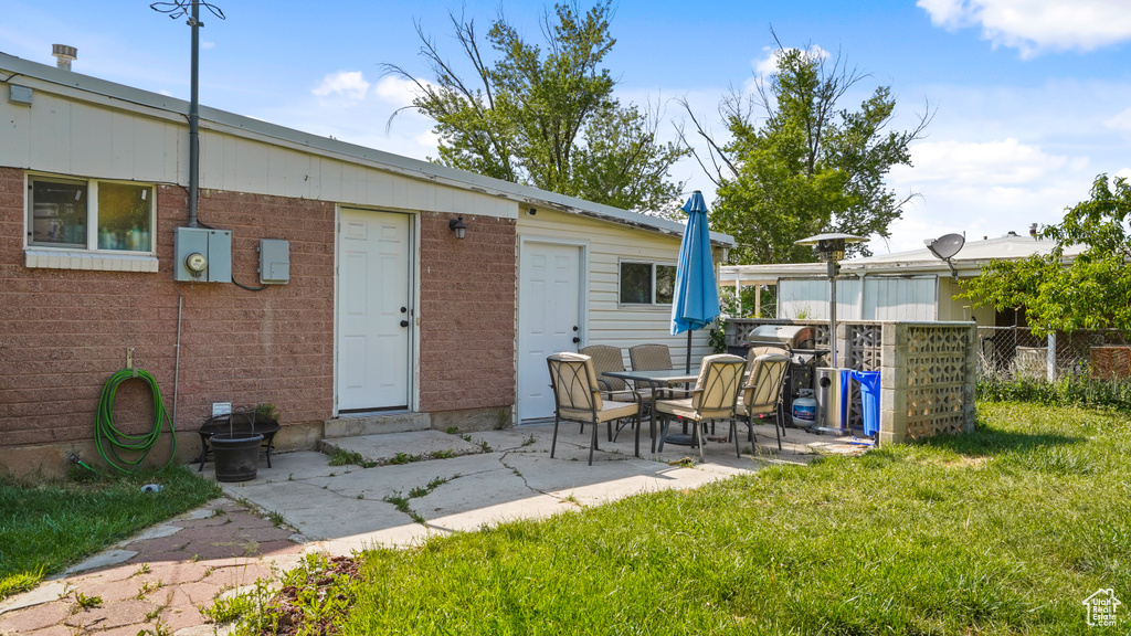Rear view of property with brick siding and a patio