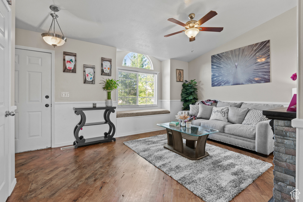 Living area featuring ceiling fan, lofted ceiling, and dark wood-style floors