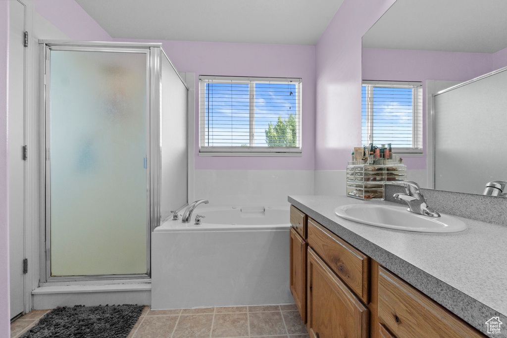 Bathroom with vanity, a shower stall, a bath, and tile patterned flooring