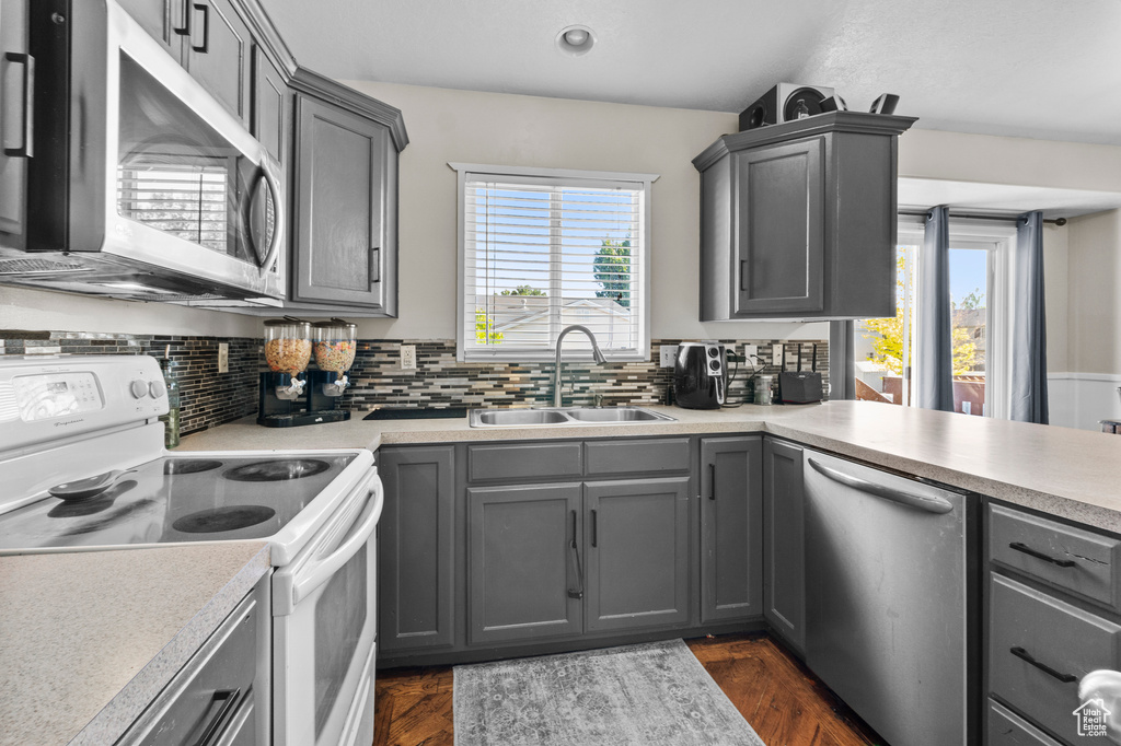 Kitchen featuring stainless steel appliances, a sink, gray cabinetry, and recessed lighting