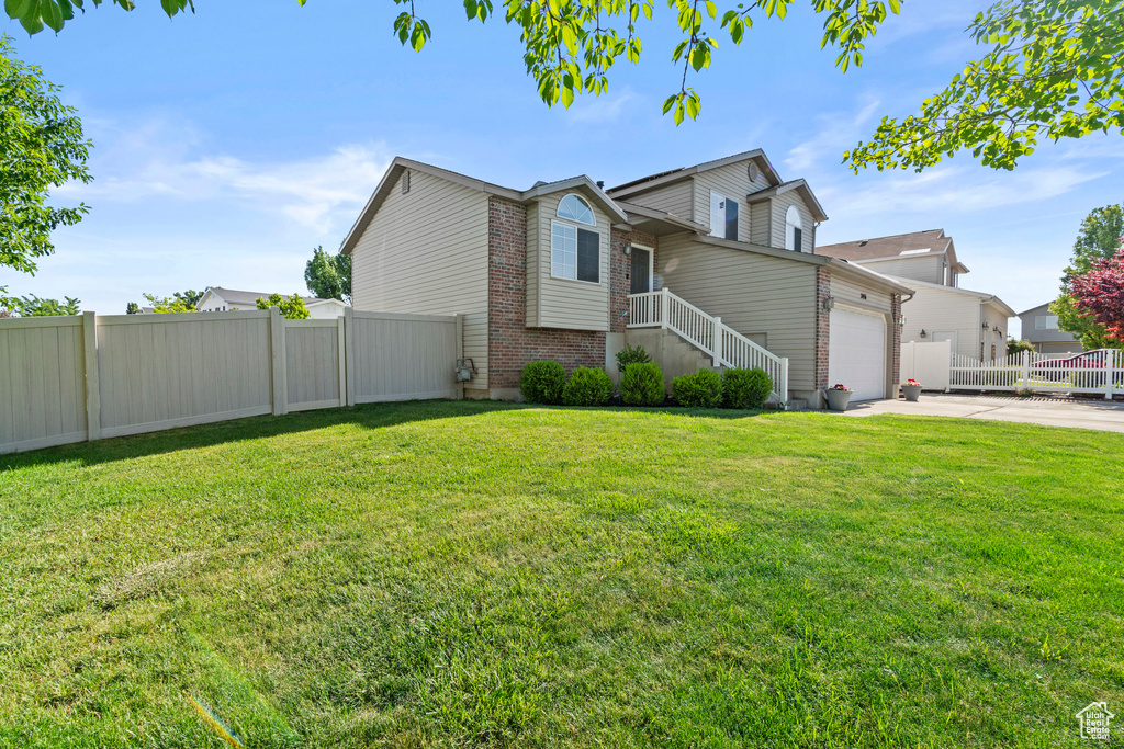 View of side of home with concrete driveway, brick siding, and an attached garage
