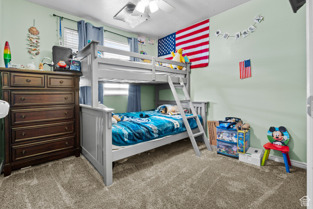 Carpeted bedroom with a ceiling fan