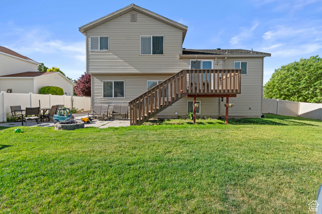 Back of property featuring a fire pit, a patio area, stairway, and a wooden deck