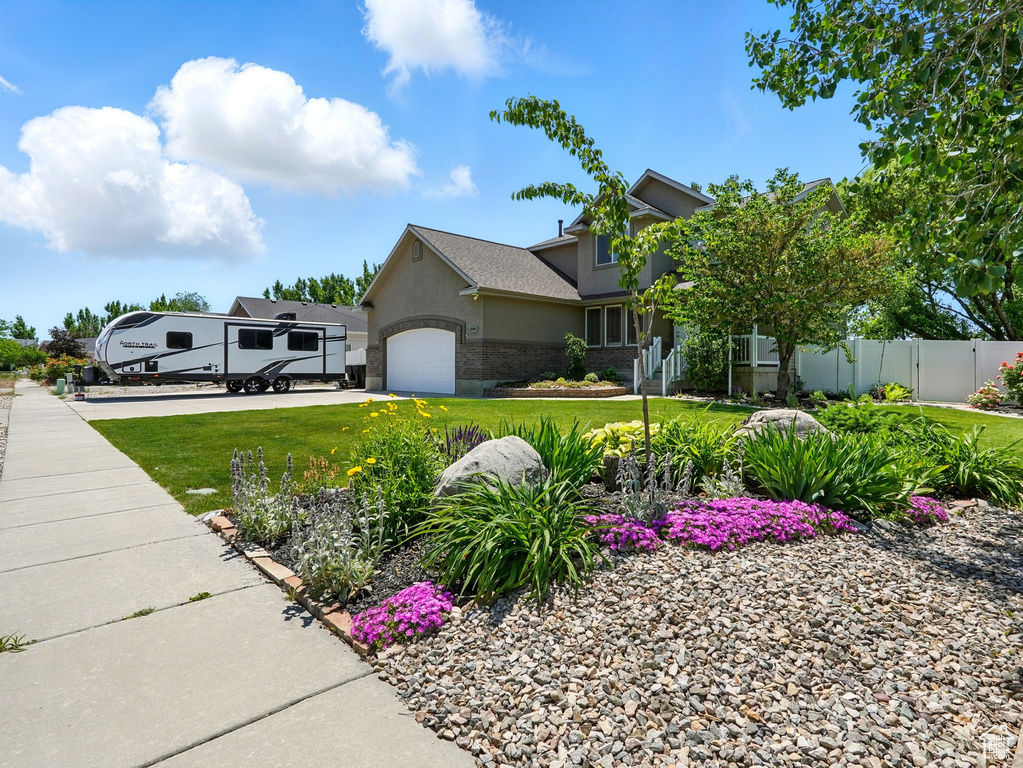 View of side of property with a garage, stucco siding, and brick siding