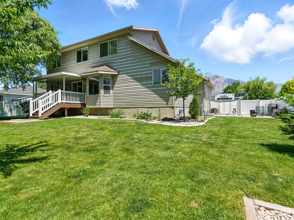 Back of house with a mountain view and covered porch