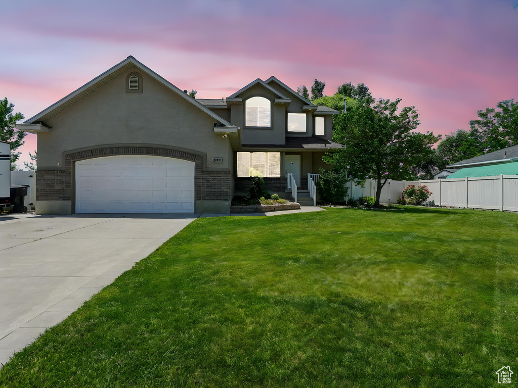 View of front facade featuring a garage, concrete driveway, and stucco siding