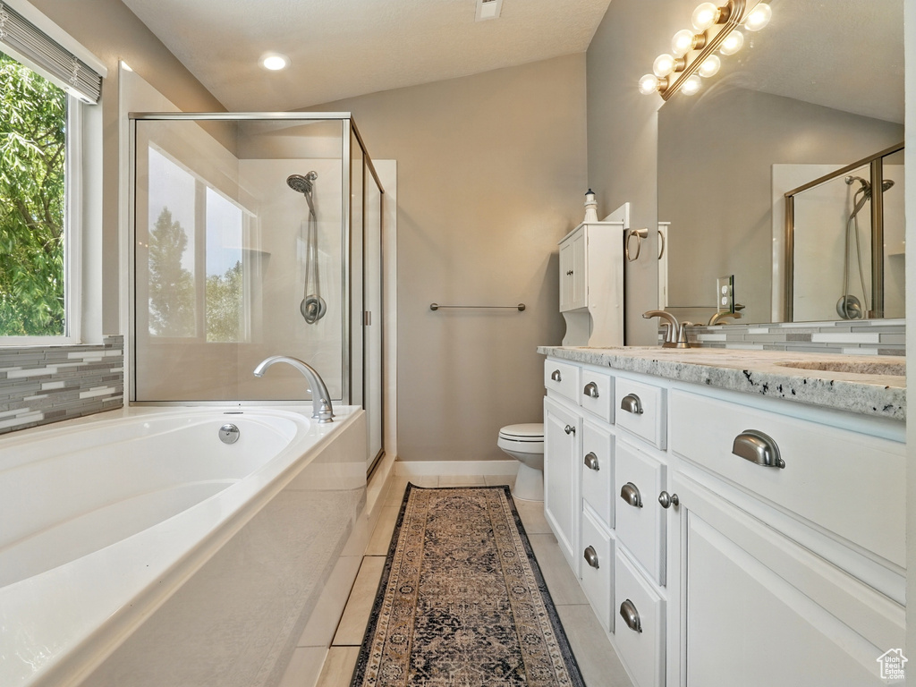Full bathroom with vanity, a shower stall, a bath, tile patterned floors, and toilet