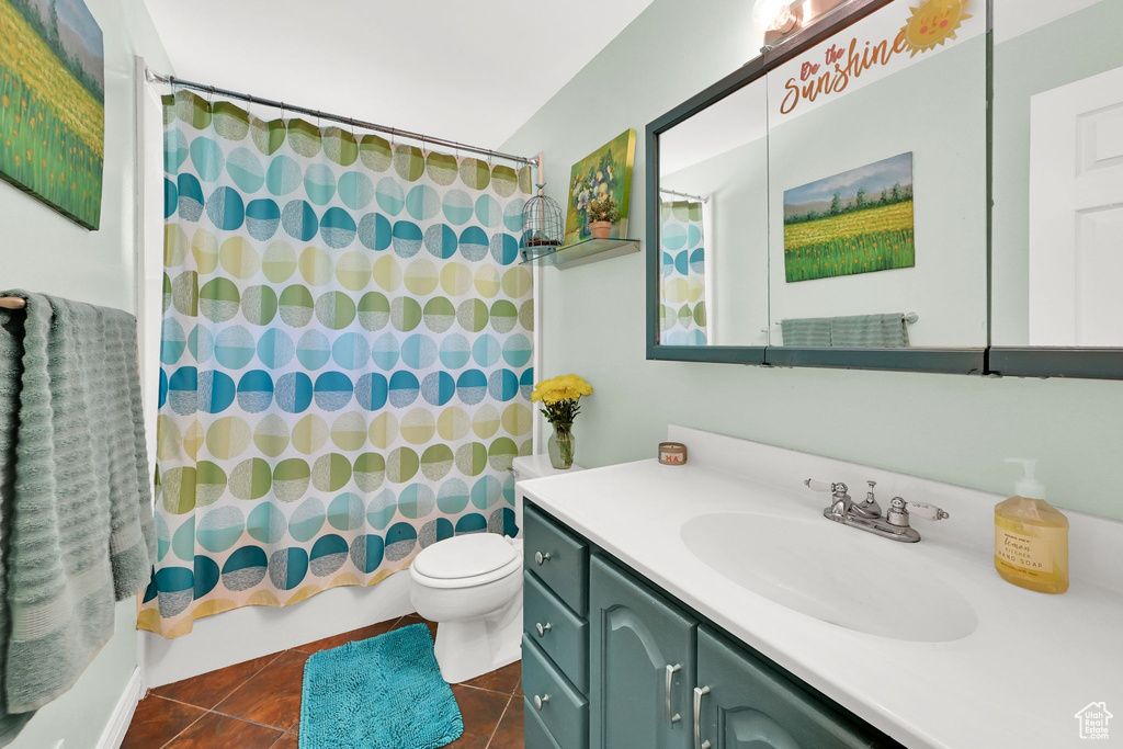 Full bathroom featuring vanity, toilet, tile patterned floors, and shower / bathtub combination with curtain