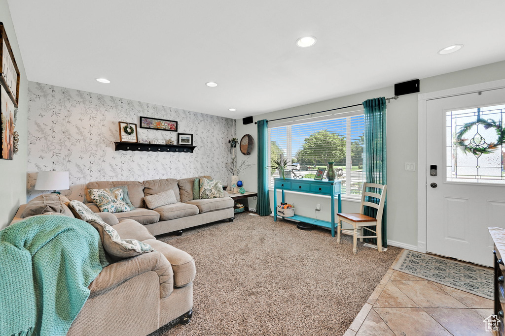 Living room with recessed lighting, healthy amount of natural light, wallpapered walls, baseboards, and an accent wall