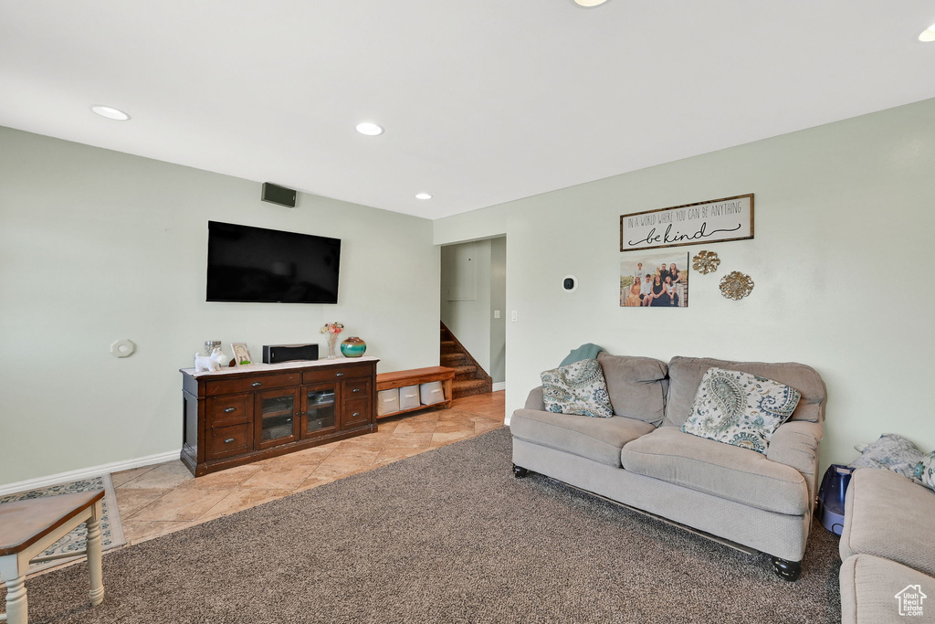 Living area with recessed lighting, baseboards, stairs, and light tile patterned floors
