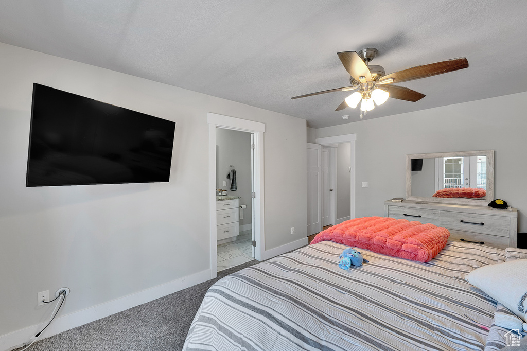 Bedroom with carpet flooring, baseboards, ceiling fan, and ensuite bathroom