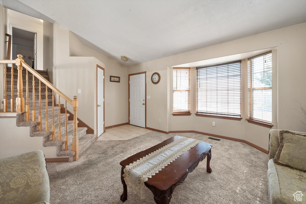 Foyer with carpet flooring, stairway, and baseboards