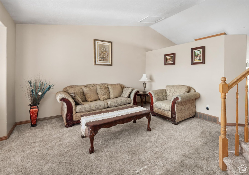 Carpeted living room with lofted ceiling and baseboards