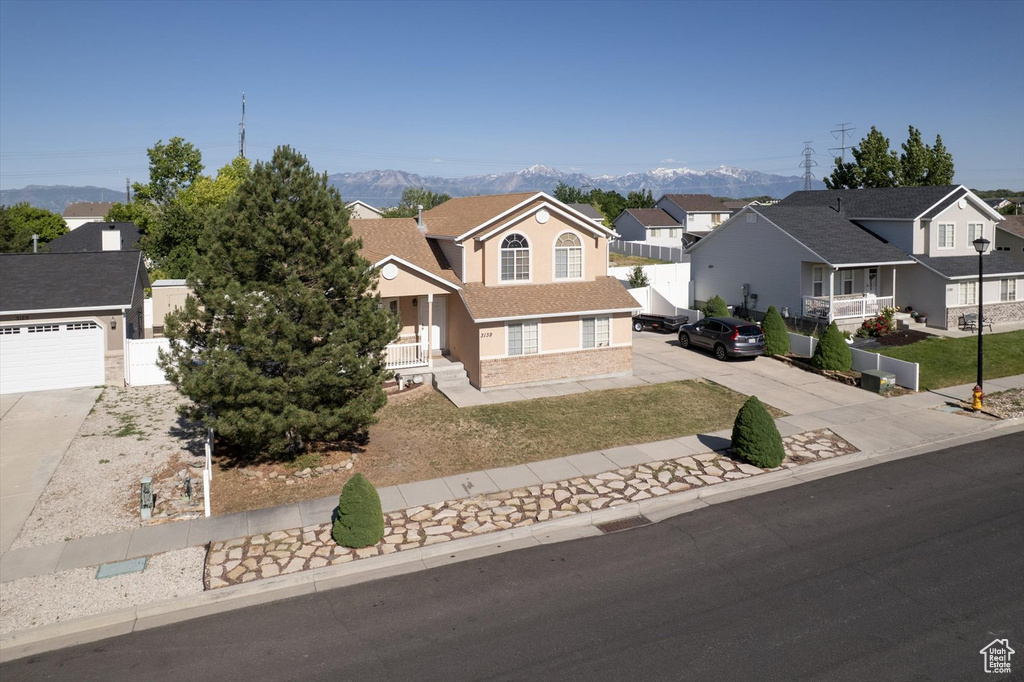 Traditional home featuring driveway, a mountain view, a residential view, and a garage
