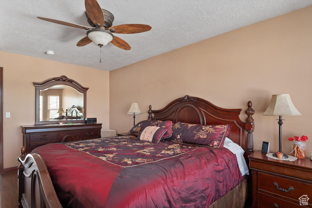 Bedroom featuring wood finished floors, a textured ceiling, and ceiling fan