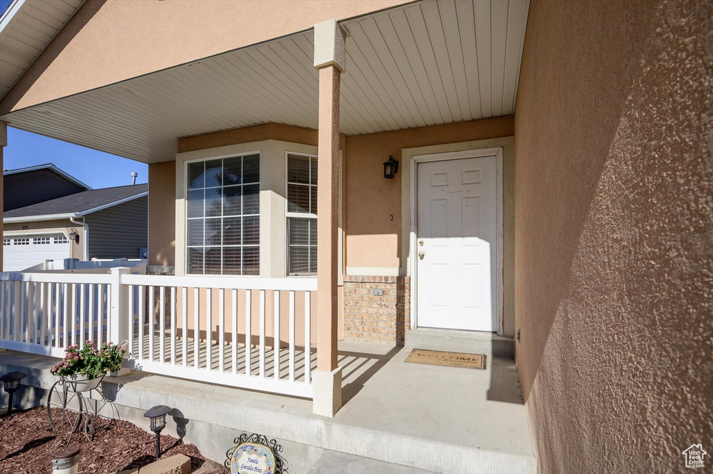 Entrance to property featuring stucco siding and covered porch