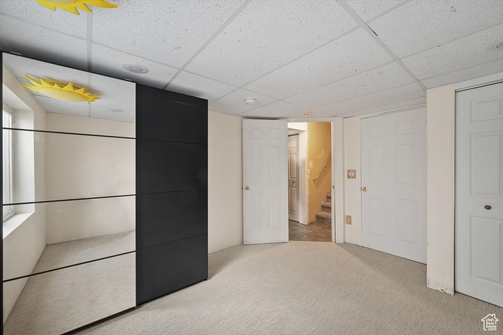 Unfurnished bedroom featuring a paneled ceiling and carpet flooring