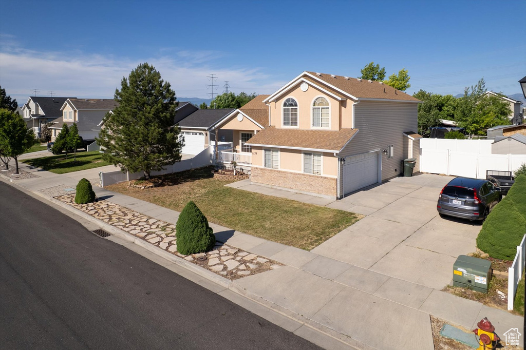 View of front of house featuring driveway, a garage, and brick siding