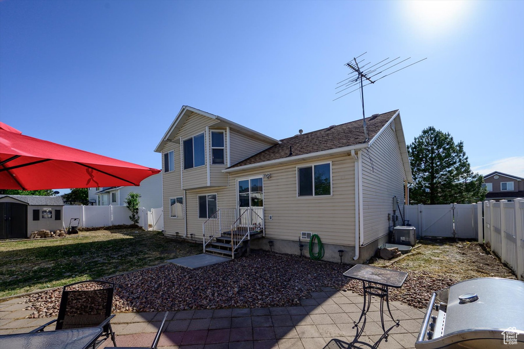 Rear view of property featuring a patio area and a gate