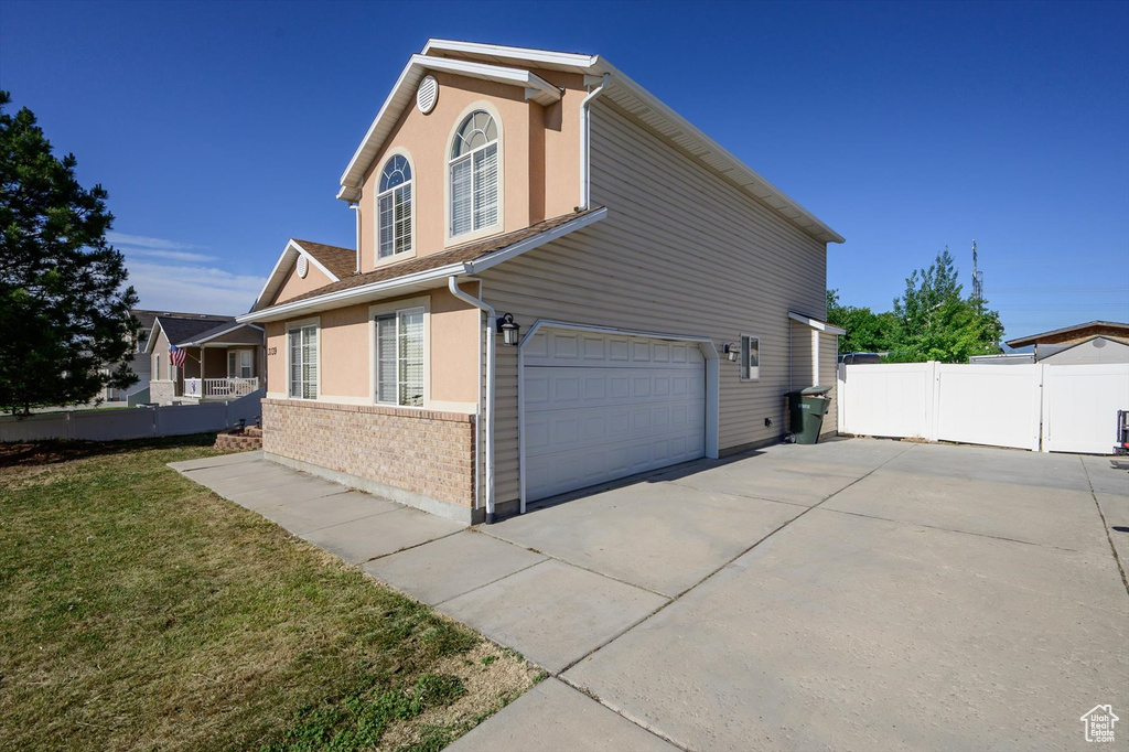 View of property exterior featuring a garage and concrete driveway