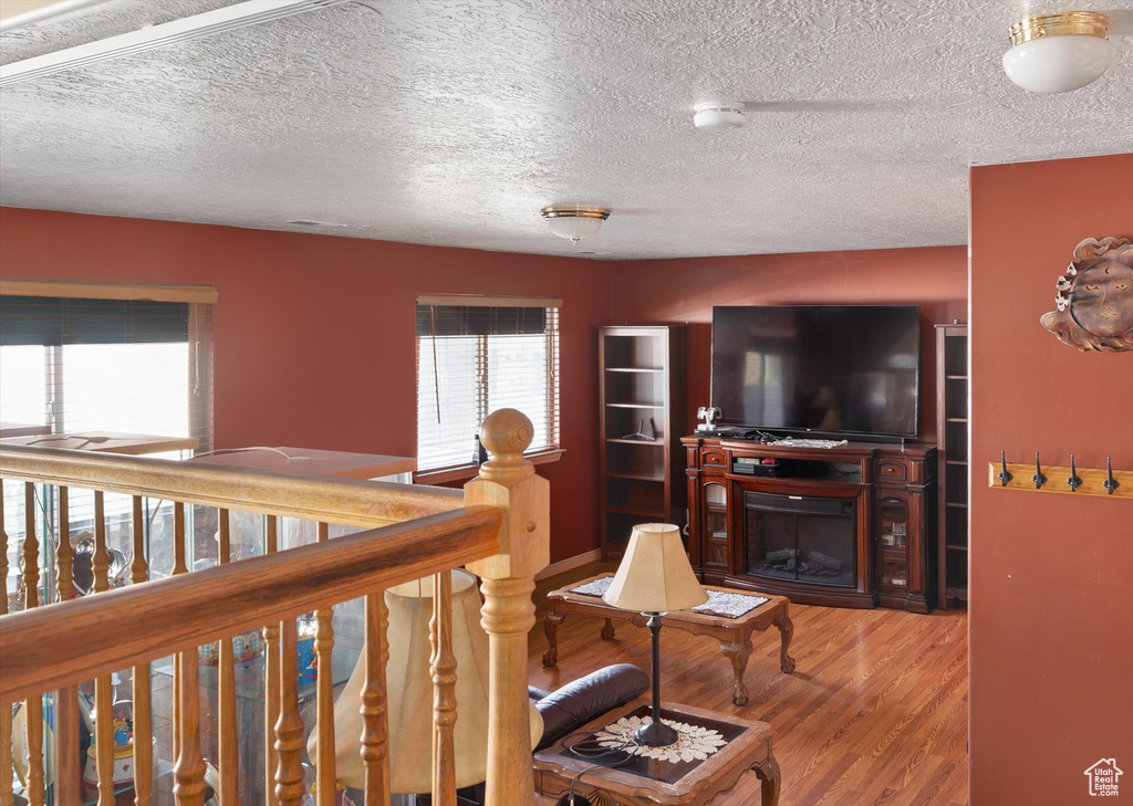 Living area featuring wood finished floors and a textured ceiling