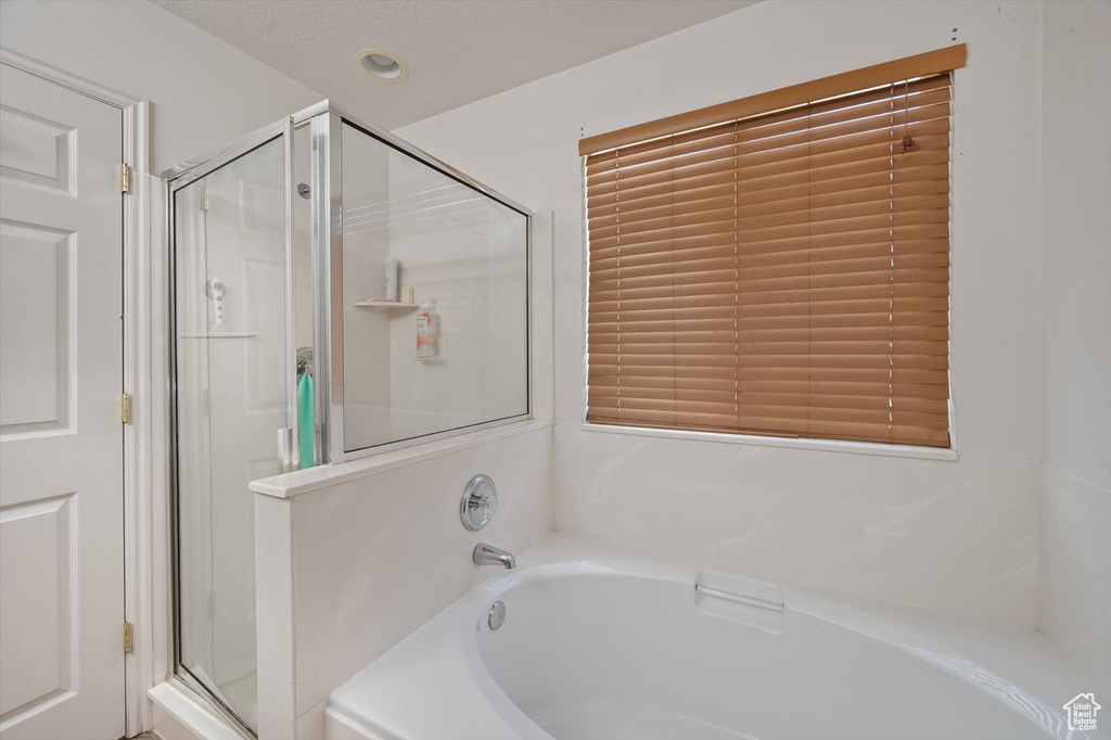 Full bathroom featuring a stall shower and a bath