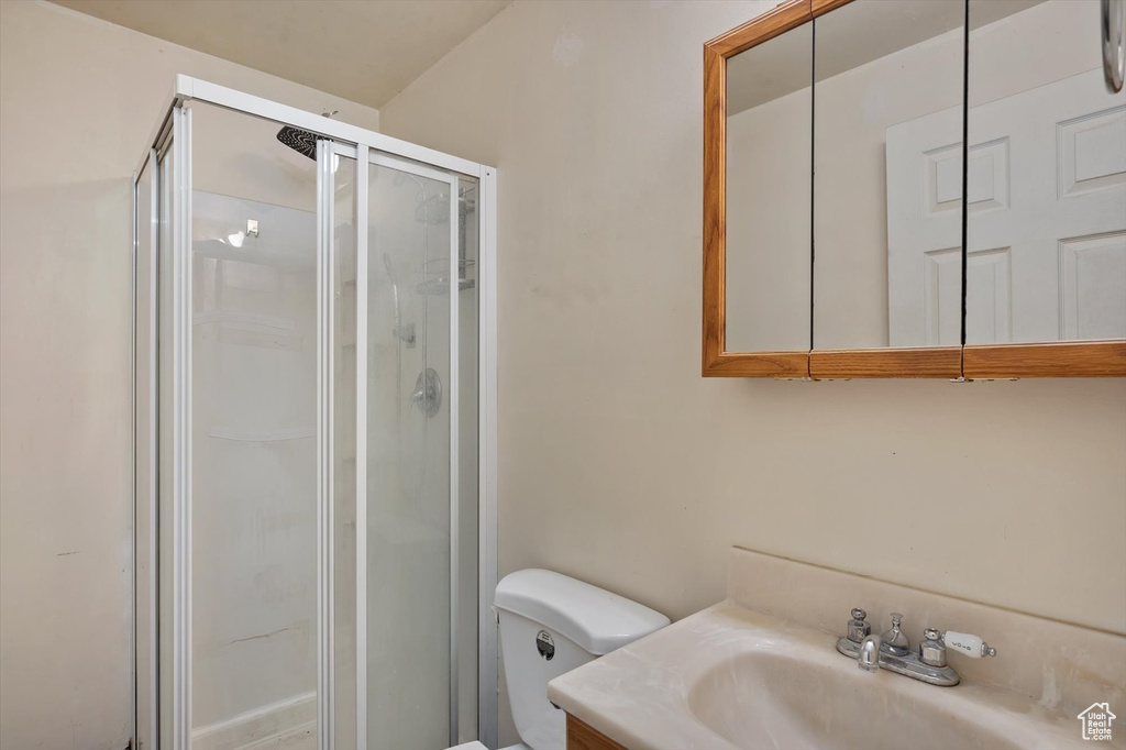 Bathroom with a stall shower, toilet, and vanity