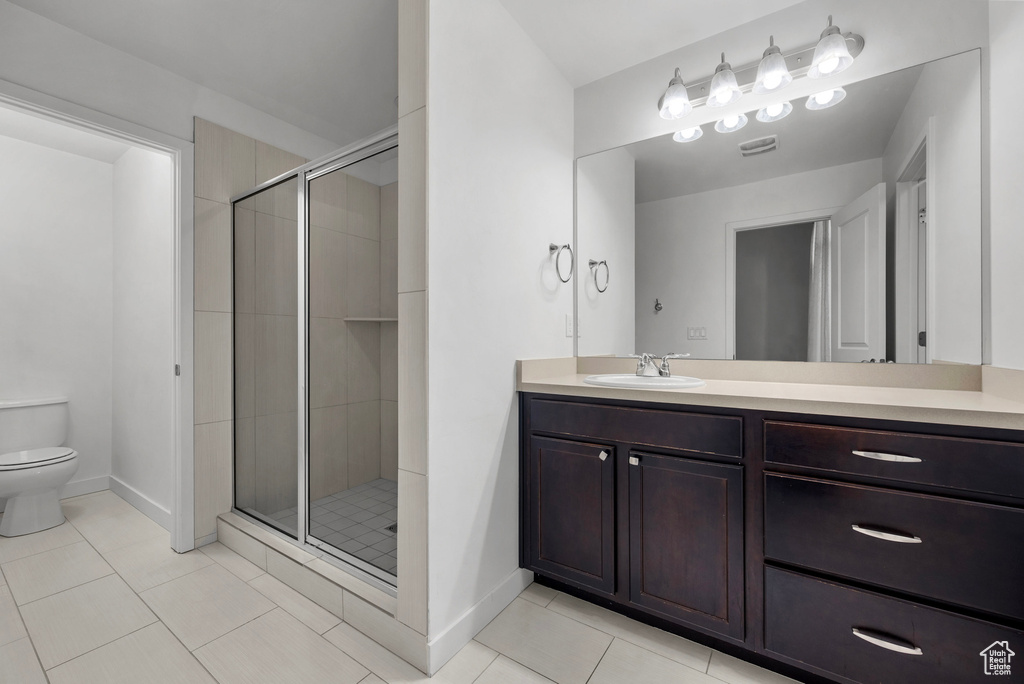 Full bathroom with vanity, a stall shower, and tile patterned flooring