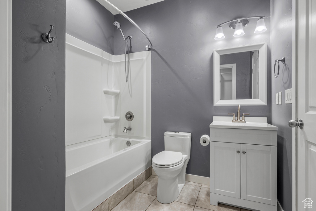 Bathroom with shower / tub combination, vanity, and tile patterned floors