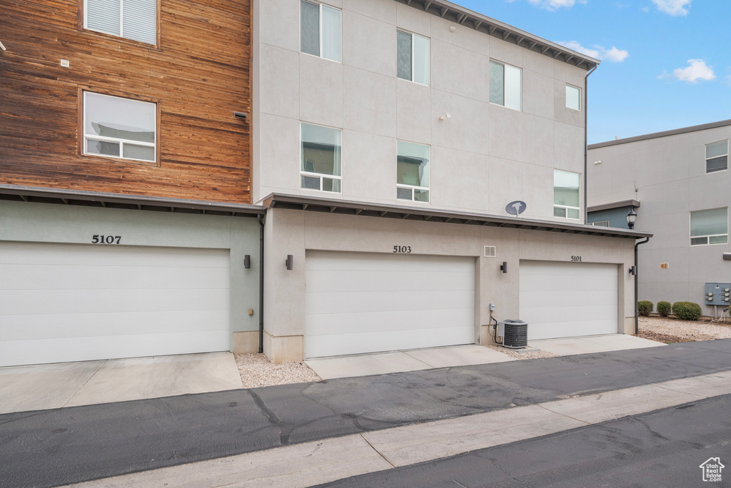 Back of property with an attached garage and stucco siding