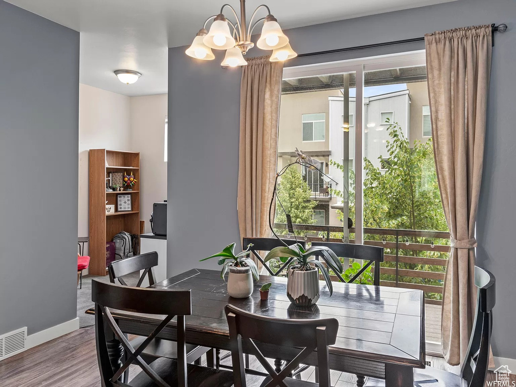 Dining area with baseboards, wood finished floors, and a chandelier